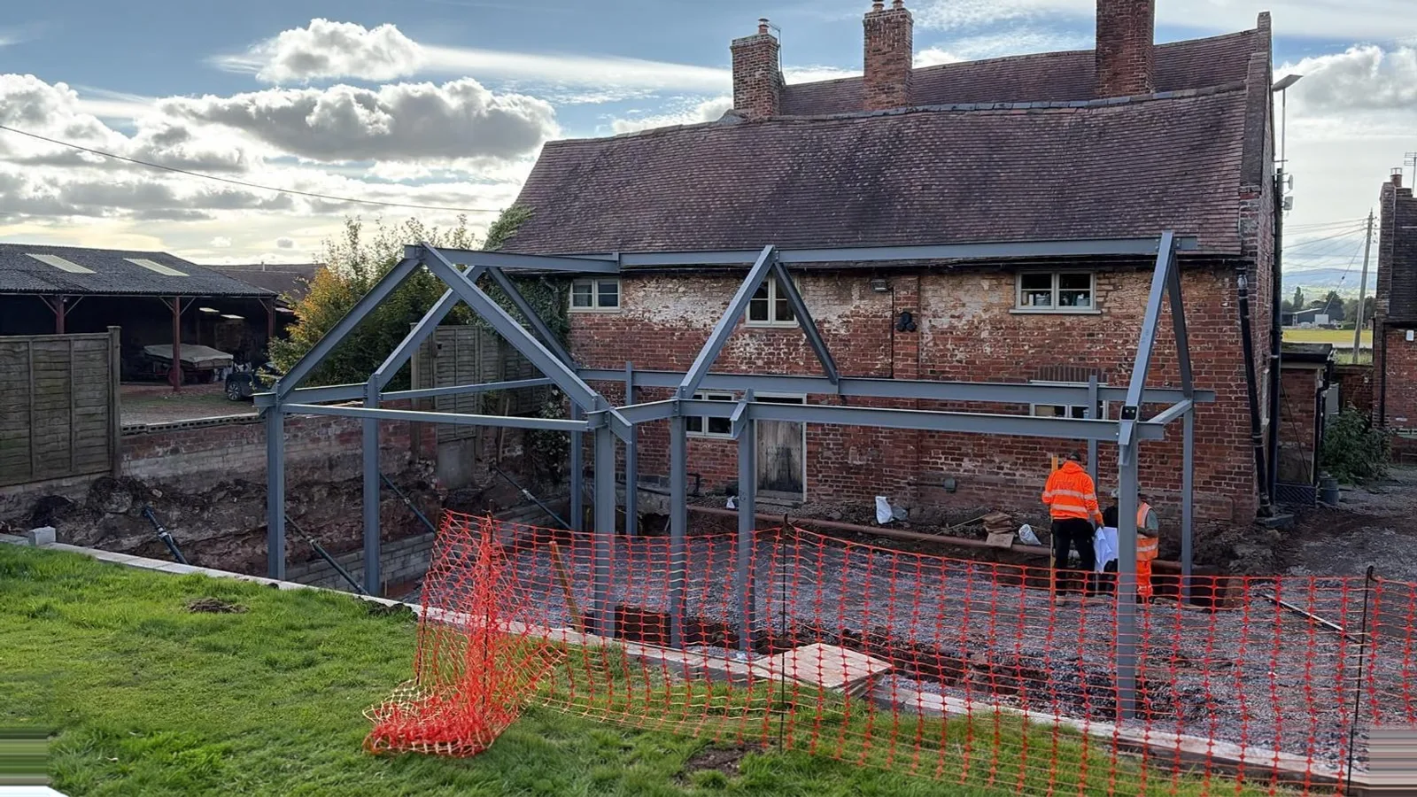 Finished steel portal frame extension on a brick farmhouse
